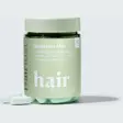 Grønn boks med Hairlust Hair Formula Tablets for Men og to lyse grønne tabletter foran