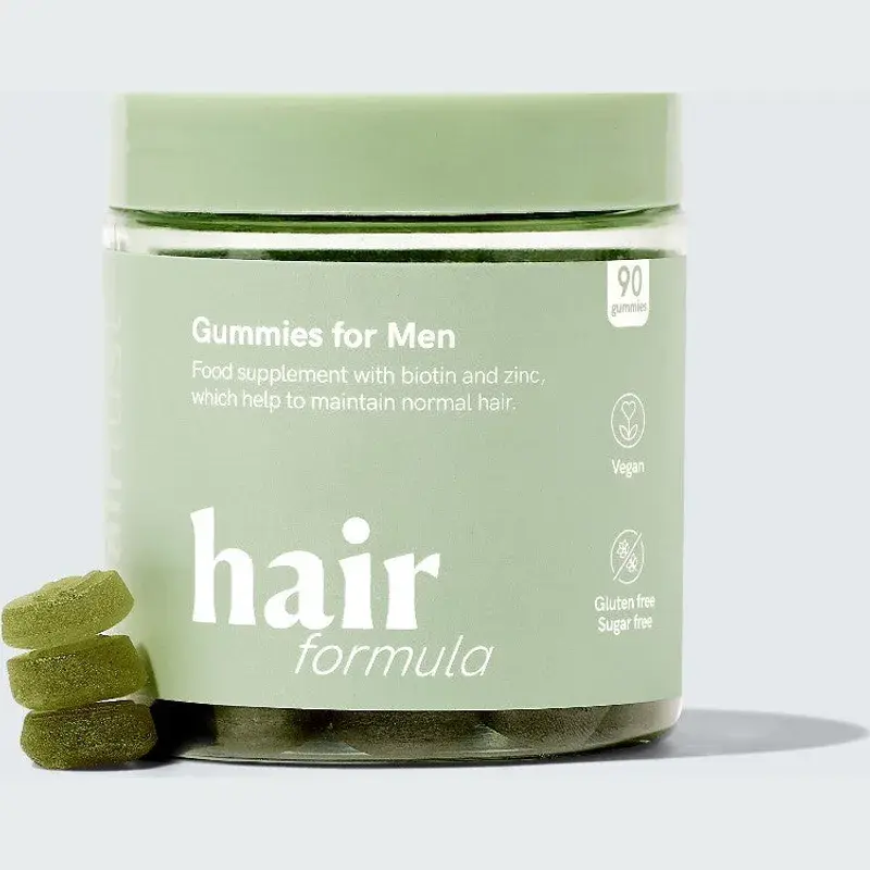 Grønn boks med Hairlust Hair Formula Gummies for Men og tre grønne vingummier ved siden av