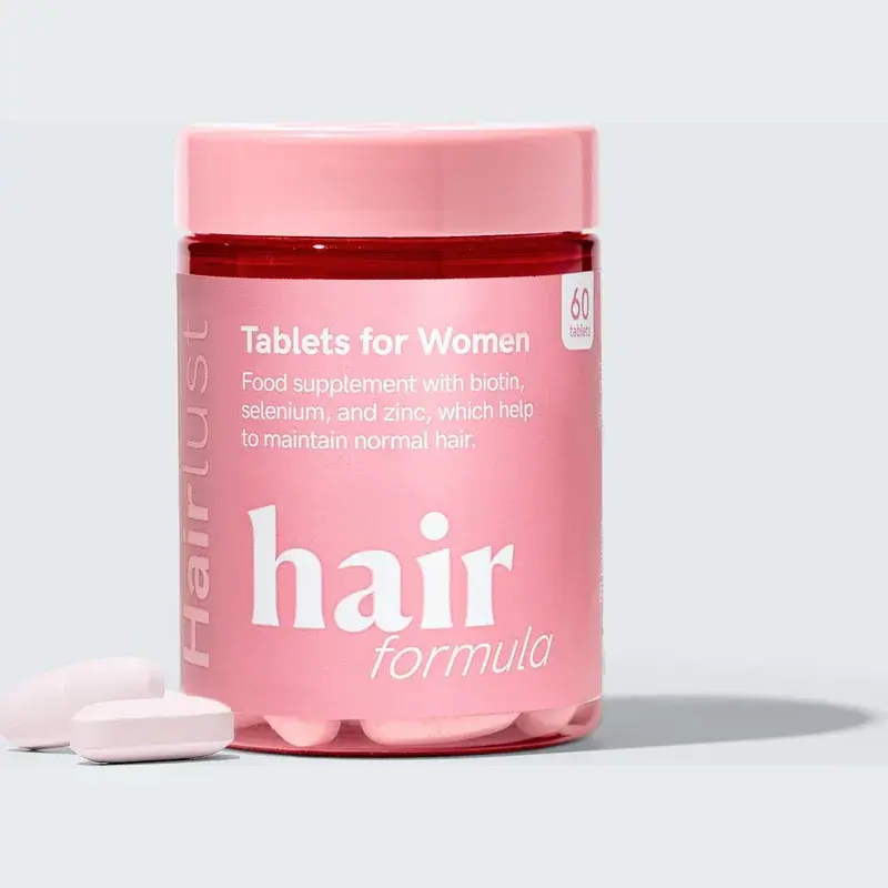 Rosa boks med Hairlust Hair Formula Tablets for Women og to lyse rosa tabletter foran